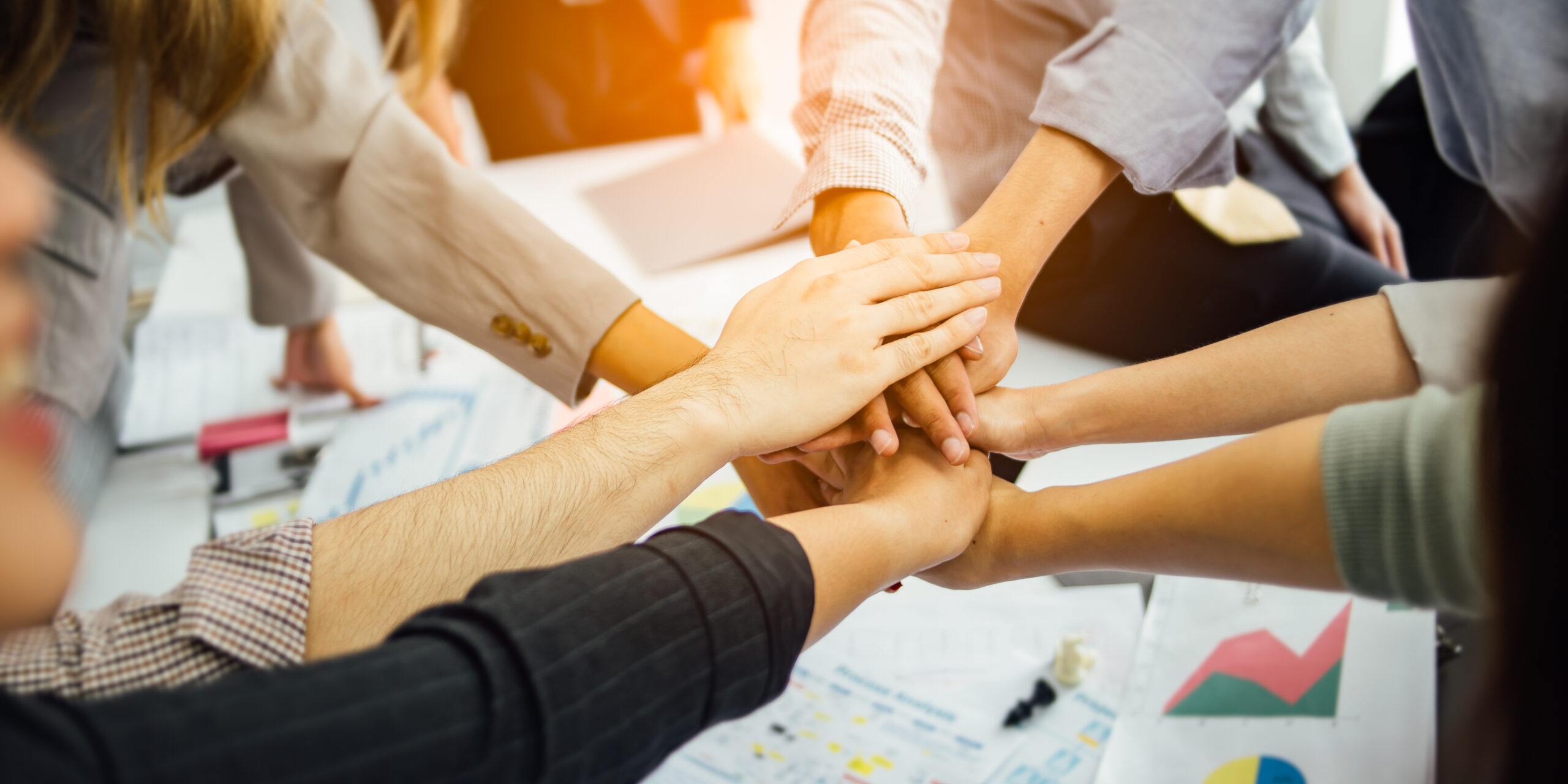 Business people join hand together during their meeting.success and winning concept - happy business team celebrating victory in office.