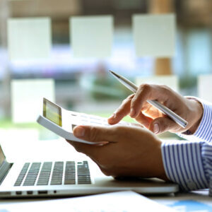 Close up Business man using calculator and laptop for do math fi